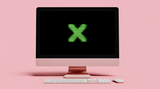 A pink, iMac-style desktop computer with a keyboard and mouse sits against a solid pink background. On the computer's black screen is a large, bright green "X" that appears to be made of digital text or code.