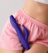 A person holding the dark purple FemmeFunn Booster Rabbit XL against their thigh.