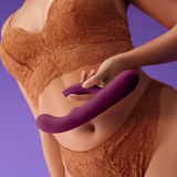A person holding the dark fuchsia FemmeFunn Balai vibrator against their stomach.