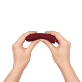 A pair of hands bending the red Booster Bullet to show its flexibility.