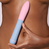 Lifestyle image of a person holding the light blue and pink ffix Bullet XL against their bare torso.