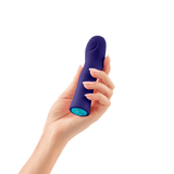 A hand holding the dark purple FemmeFunn Hana Bullet to show its size and how it fits in hand. 