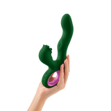 A hand holding the dark green FemmeFunn Pallina rabbit vibrator.