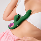 A person holding the dark green FemmeFunn Pallina vibrator against their side.